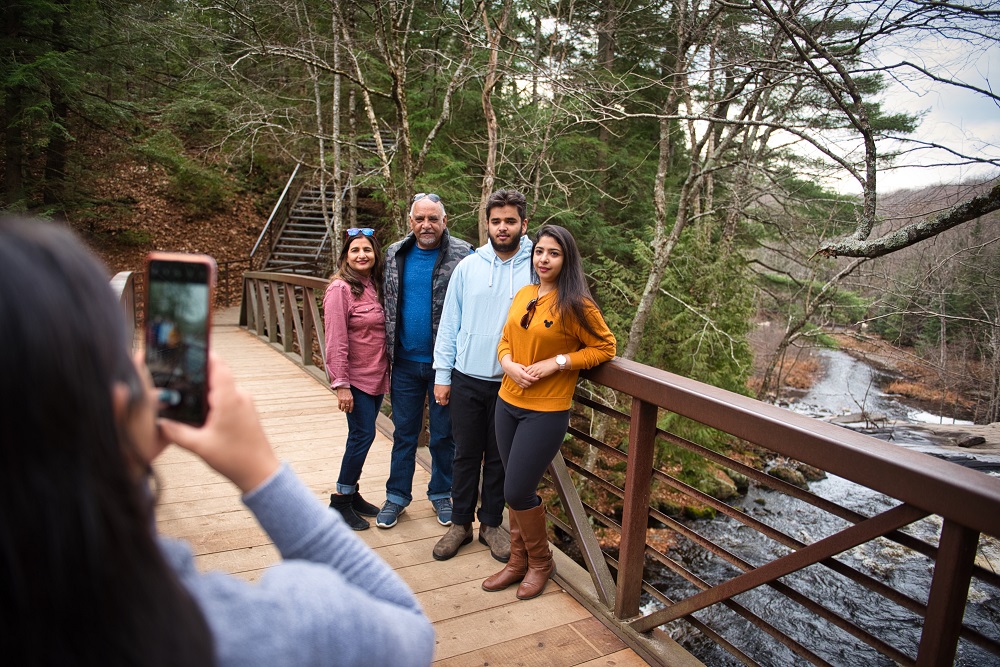 family posing for photo on bridge