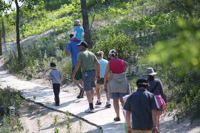 people on a boardwalk over sand