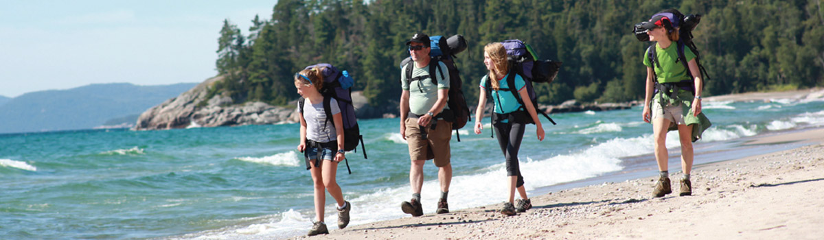 Three people hiking on a beach