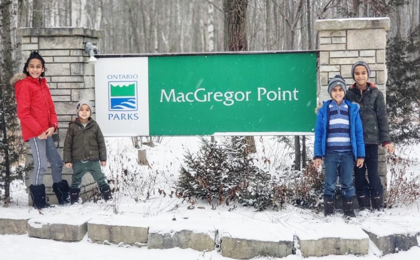 Enfants debout devant une enseigne du parc provincial MacGregor Point