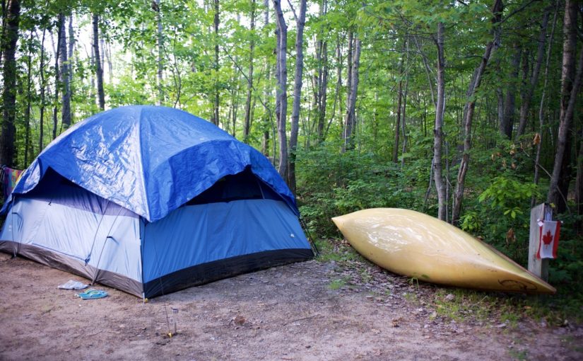 Emplacement de camping avec tente et canot