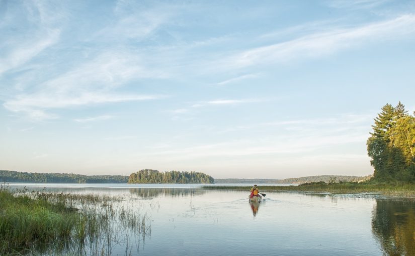 person canoeing on lake