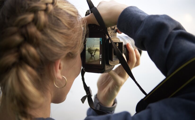 person looking through viewfinder of camera