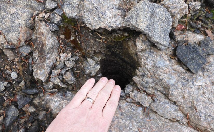 hand near hole in rock